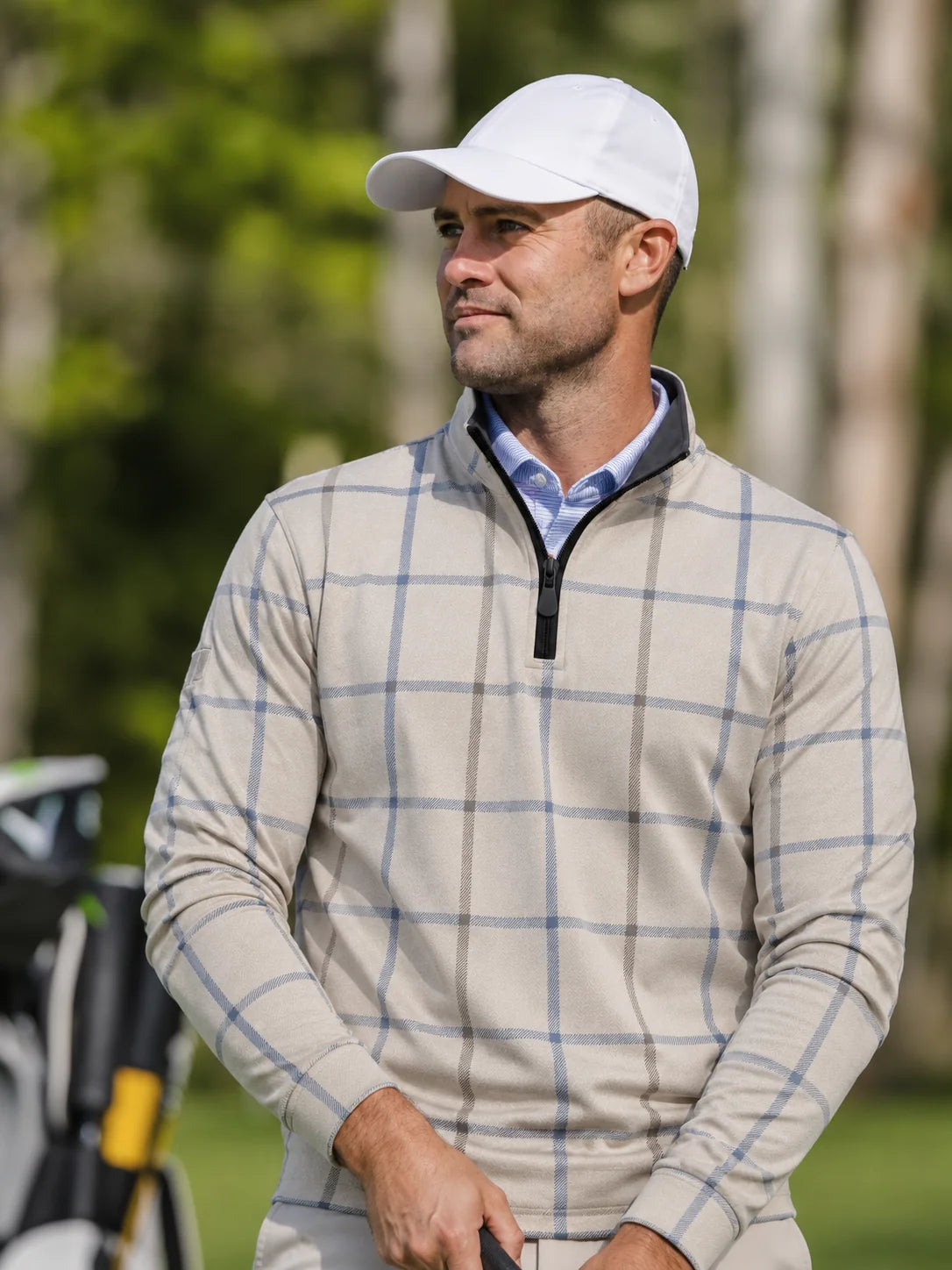 Cremefarbener Golfpullover aus Funktionsmaterial mit blauem Karomuster und kurzem Reißverschluss
